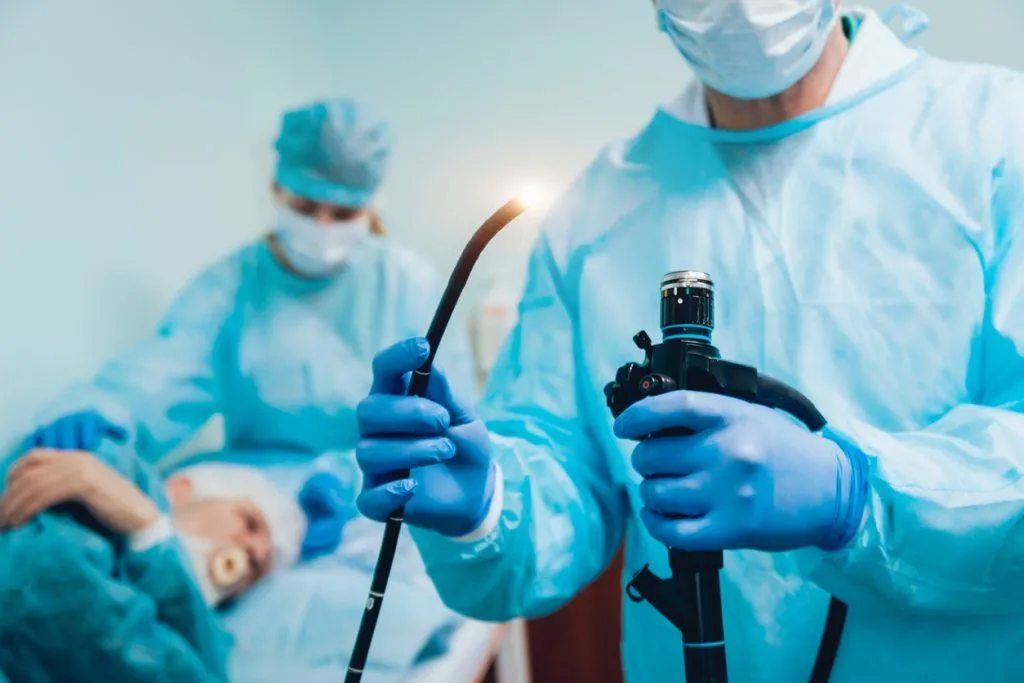صورة لأطباء يقومون بعملية منظار المعدة أو تظهر جهاز المنظار مع شاشة تعرض صورة المعدة من الداخل.
