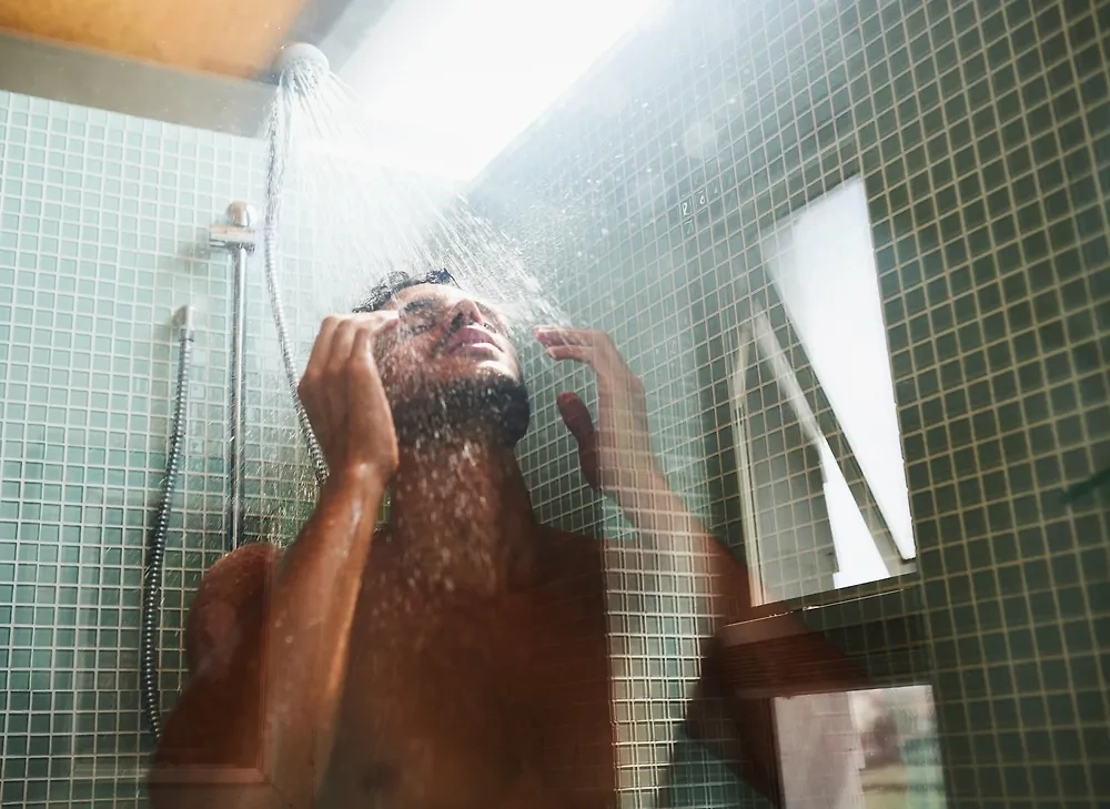 صورة شخص يأخذ دشًا قصيرًا بماء فاتر مع حمام جيد التهوية.