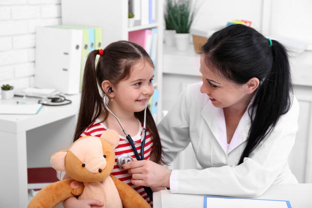 صورة طبيب يفحص وجه طفل لغرض علاجي أو تصحيحي.