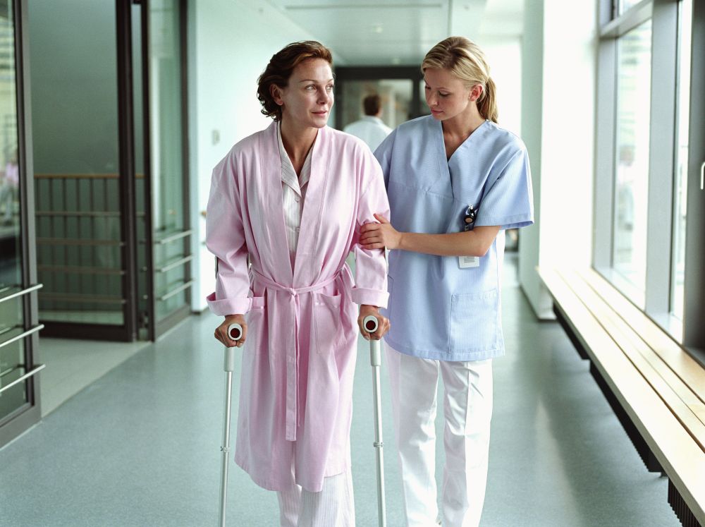 مريضة تمشي ببطء في منزلها مرتدية بيجاما مريحة